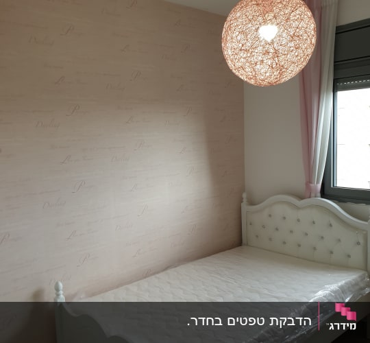קיר חדר שינה מעוצב עם טפט בדוגמה עדינה בגוון ורוד בהיר